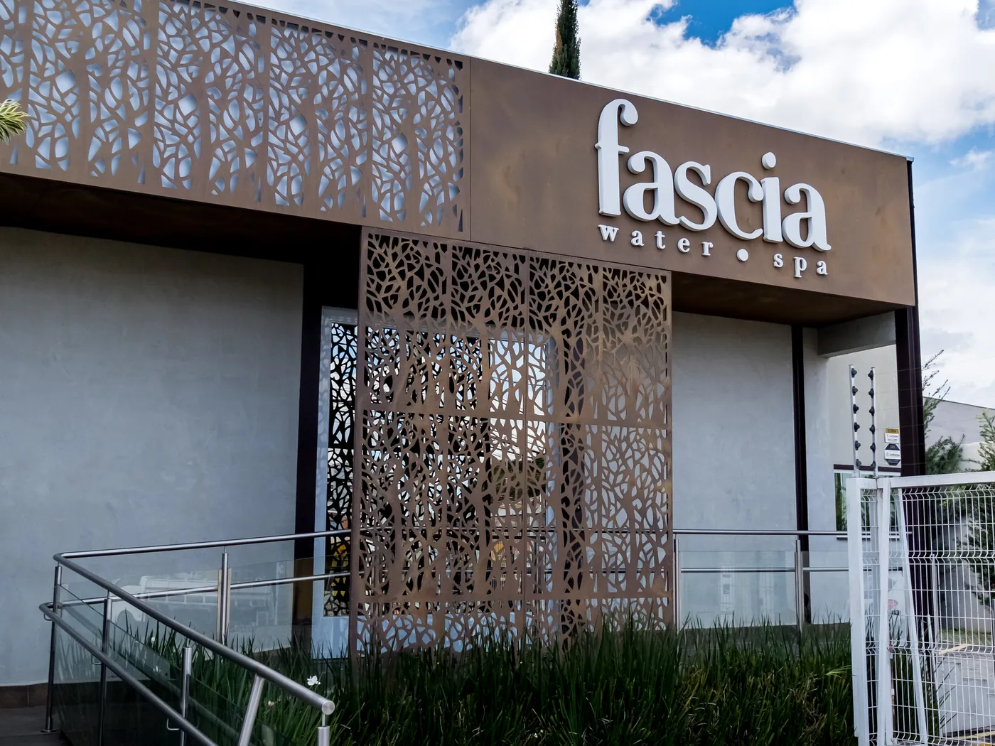 Entrada da Fascia Water Spa com jardim e painéis vazados
