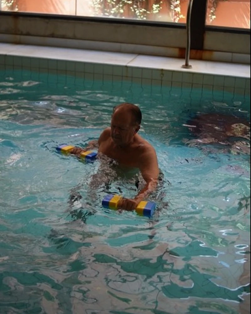 Paciente fazendo hidroterapia com halteres na piscina aquecida do Fascia